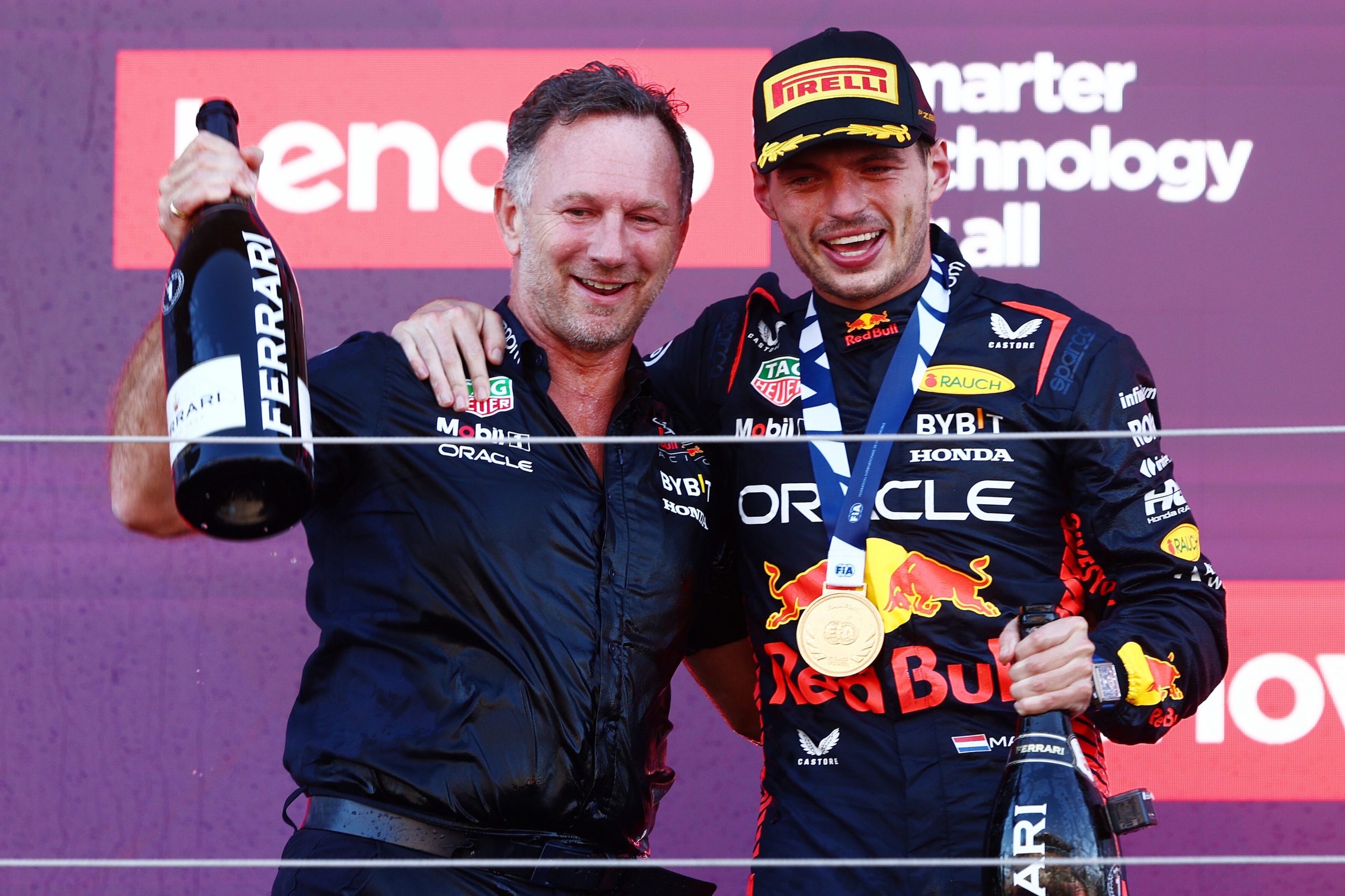 Christian Horner and Max Verstappen on the podium holding champagne at the Formula 1 Japanese Grand Prix. This was after claiming the Constructors' Championship. 